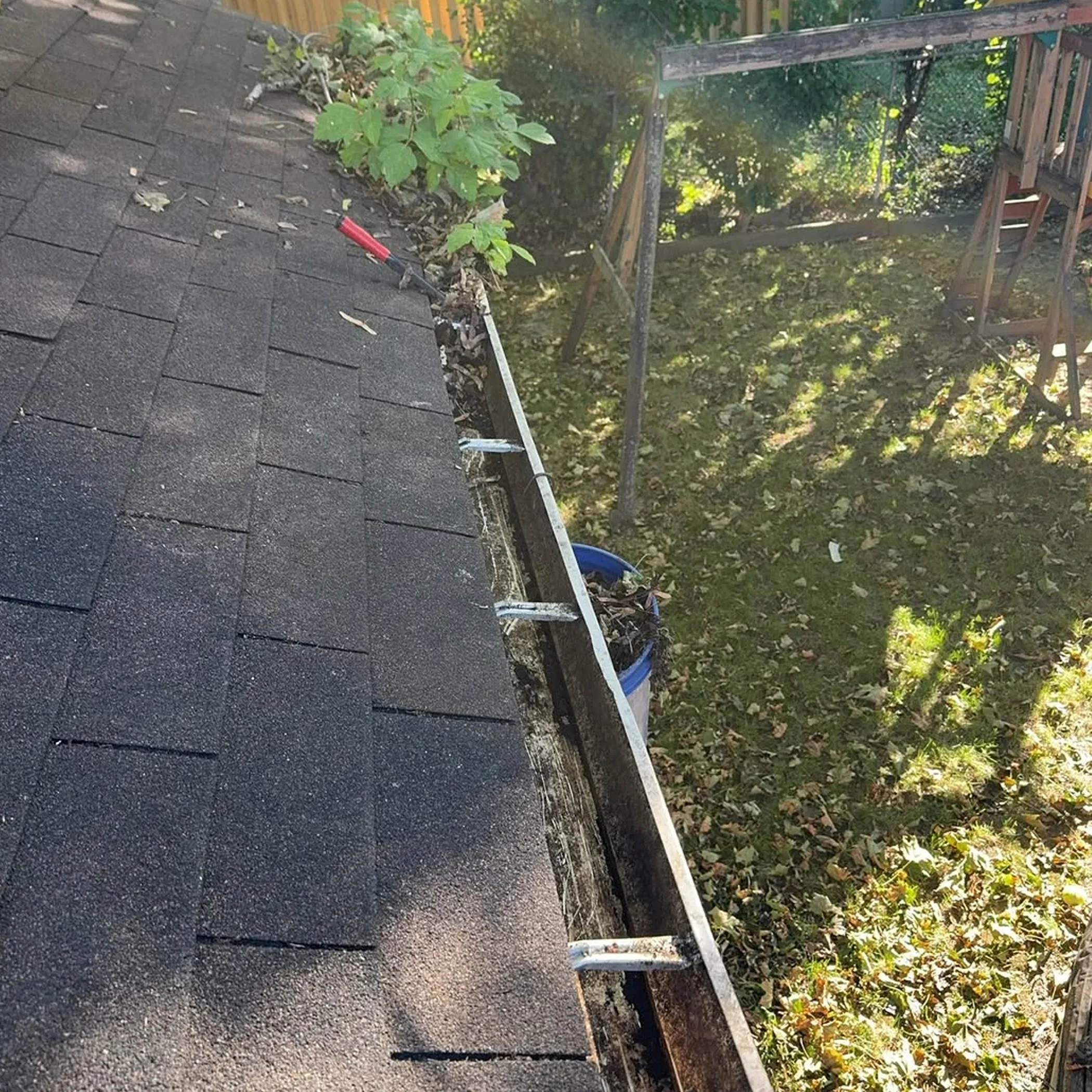 debris-filled gutters being cleaned